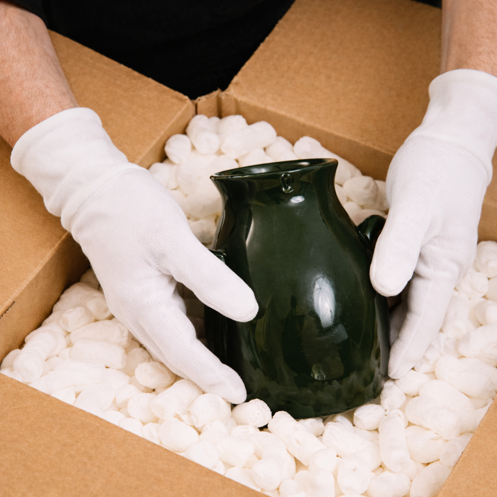 Carefully packing a delicate vase with protective cushioning, demonstrating Muber Moving's white-glove handling and professional